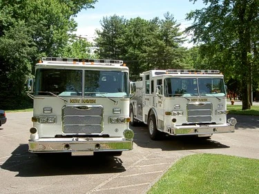 Head-on view of both pumpers showing grilles, windshields, and front bumper intake fittings.