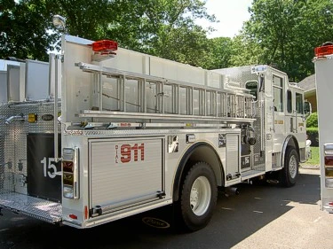 Rear right angle showing hosebed side, rear compartment doors, and wheel/tire area.