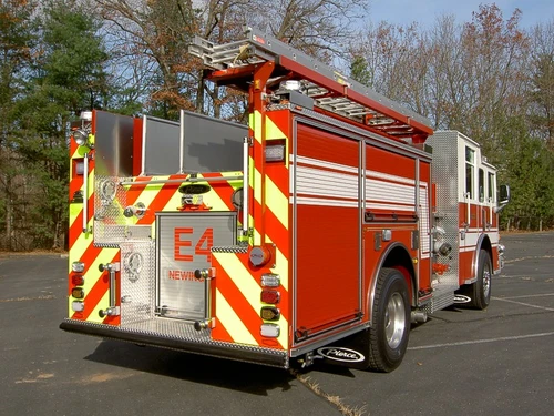 Rear right angle showing red-yellow chevrons, rear door, upper ladder storage, and tail lights.