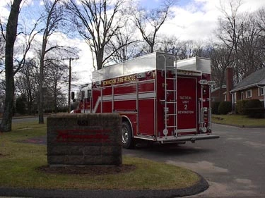 Rear right angle showing back corner ladders, rear step area, and side roll-up compartment doors.