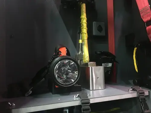 Open compartment close-up showing mounted flashlight and small tools