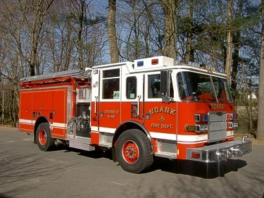 Front-right exterior view of pumper showing cab, side body, and roof ladders