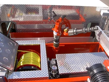 Hosebed close-up showing deck gun nozzle and yellow hose reel in compartment