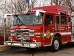 Front-left thumbnail view of the pumper parked beside the Pierce sign.