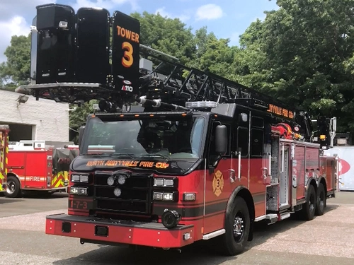 Pierce Ascendant tower ladder front-left exterior view with aerial ladder and bucket raised over cab