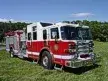 Wide front left view of the parked pumper showing bumper, cab, and full body profile.