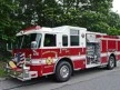 Wide front left view of the parked pumper showing bumper, cab, and full side body.