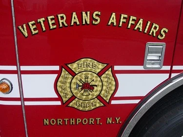 Close-up of a side door emblem and lettering on the red cab panel above the wheel arch.
