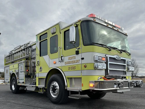 Front-right exterior view of lime pumper showing grille, bumper, and side pump panel