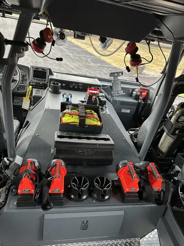 Cab interior rear view showing center console, portable lights, and crew seating