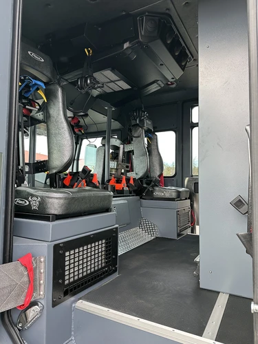 Rear crew seating view showing SCBA seats, harnesses, and raised floor walkway