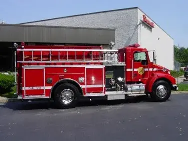 Driver-side profile view showing side hosebed rails and tank body compartments