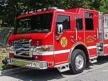 Wide front left view of the parked pumper showing bumper, cab, and full side body.