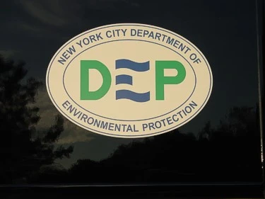Close-up of an oval side logo decal on black body paint with multicolor lettering.