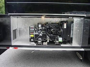 Open lower compartment showing a mounted generator or power unit with hoses, control box, and fittings.