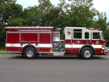 Driver-side full profile view showing pumper body and side compartments
