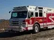 Wide front-left view of the rescue truck parked near the shoreline with full body length visible.