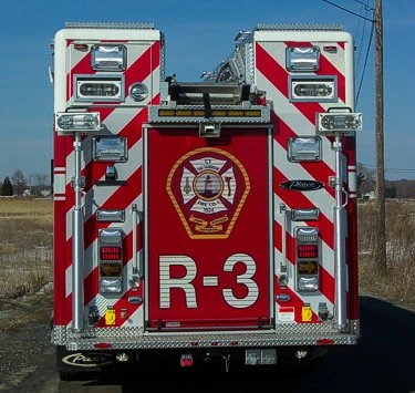 Straight rear view with diagonal striping, rear warning lights, and a large center rear door panel.