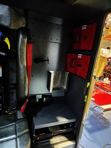 Interior seat-side storage view showing red medical bags and wall mounts