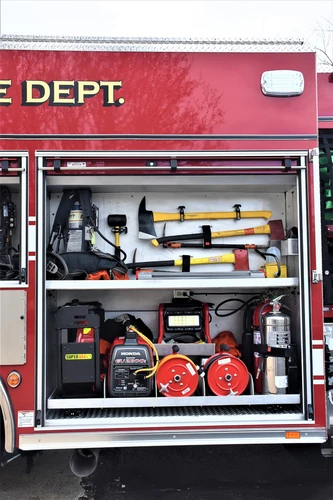 Open side compartment showing hand tools, nozzles, and shelf storage