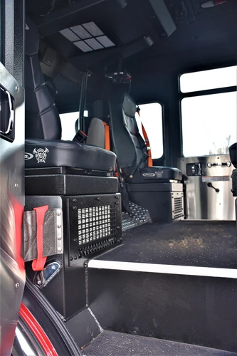 Cab interior side view showing crew seat, center aisle, and rear door opening