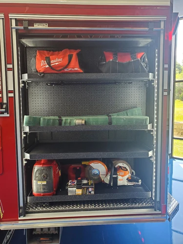 Open side compartment showing stacked safety gear and helmets