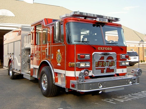 Pumper front-left exterior view showing enclosed cab, bumper, and side compartments