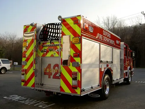 Rear-right exterior view showing chevrons, hosebed, and rear body panel