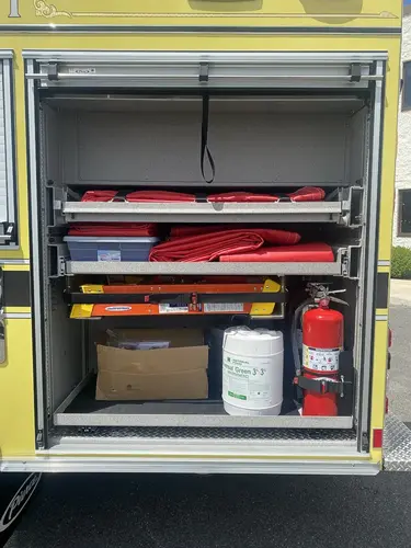 Open side compartment showing pull-out trays and mounted extinguisher
