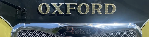 Front grille close-up strip showing Oxford script on chrome mesh