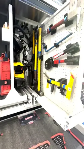 Open toolboard compartment showing mounted hand tools and clamps