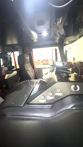 Driver cockpit view showing steering wheel, dashboard controls, and center console