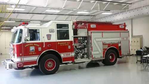 Driver-side full profile showing exposed pump panel controls, side compartments, and rear wheel area.