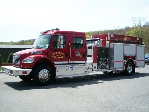 Driver-side profile view showing the open pump panel, roll-up compartments, and rear wheel area.