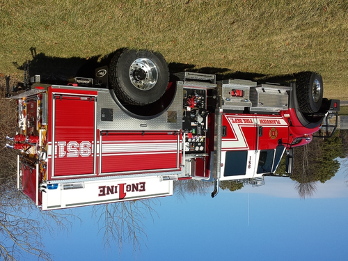 Rescue pumper passenger-side rear three-quarter view with pump panel and rear compartments