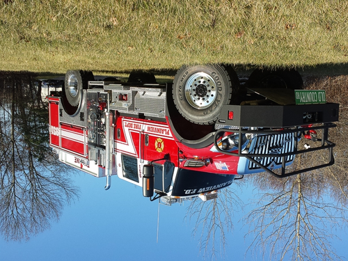 Low front-right angle showing bumper guard, cab, and side body compartments
