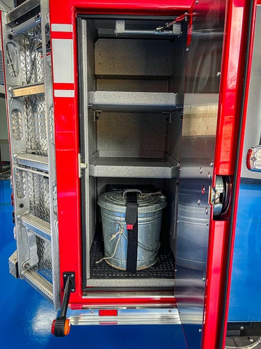 Open tall compartment showing shelves, pail storage, and lower equipment area