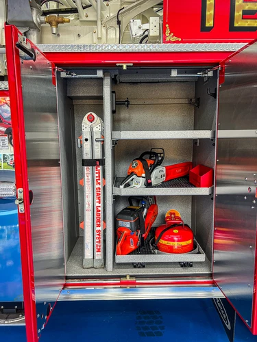 Open side compartment showing traffic cones and compartment shelving