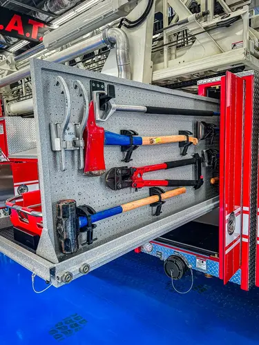 Open side compartment showing mounted nozzles, adapters, and hand tool storage