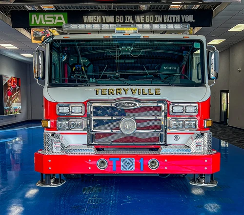 Head-on front view showing grille, bumper, and warning light bar