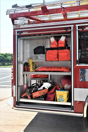 Open side compartment showing bags, cones, and shelf-mounted equipment