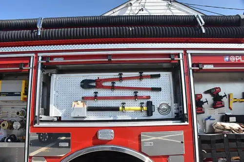 Open side compartment showing mounted hand tools and long-tool storage
