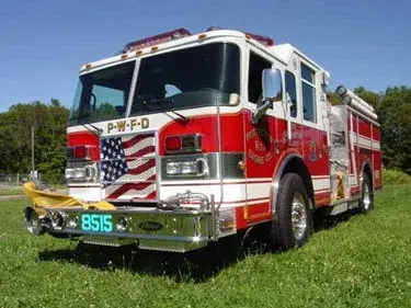 Front-left exterior view on grass showing grille and warning lights