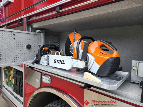 Open side compartment showing power saw and equipment storage bins