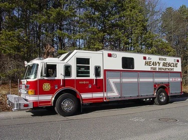 Heavy rescue truck side profile with closed compartments and roof ladder rack