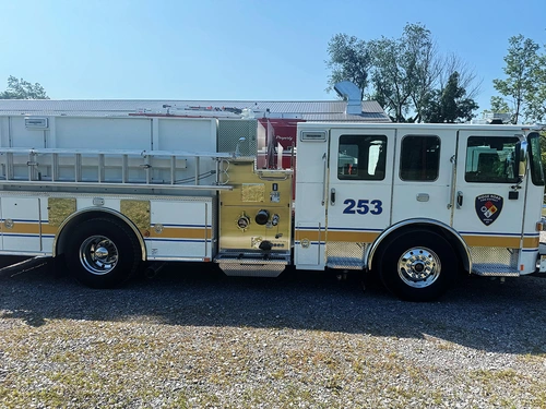Pumper driver-side profile view showing pump panel, side compartments, and roof ladder