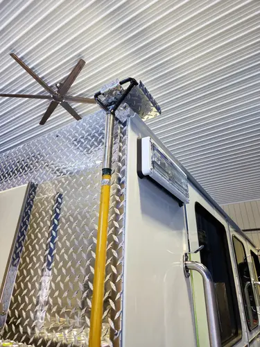 Upper body corner close-up showing mounted pike pole and warning light
