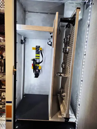 Open side compartment with mounted hydraulic tool, bottle brackets, and shelf divider