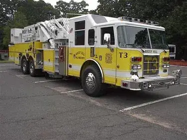 Aerial ladder truck front-left exterior view showing enclosed cab and ladder bed
