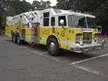 Aerial ladder truck front-left exterior view showing cab and ladder bed